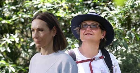 Two women standing in a forest
